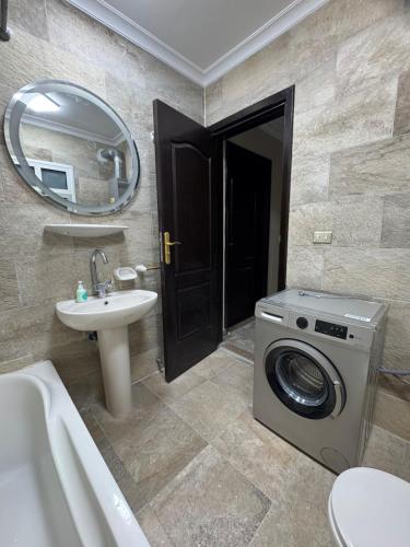 a bathroom with a washing machine and a sink at Privado Modern Apartment Garden View B11 Group114 2BR in Madinaty