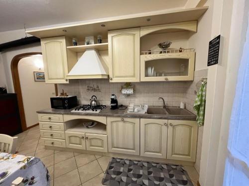 Casa di Marina في سان جيوفاني بيانكو: مطبخ بخزائن بيضاء ومغسلة