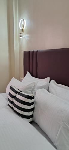 uma cama com uma almofada preta e branca em Lake View House- Shawmut Nakuru em Nakuru