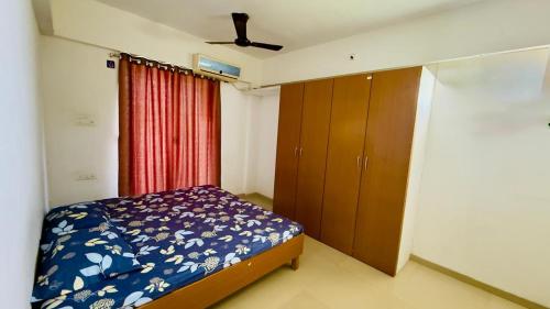 a bedroom with a bed and a dresser in it at Newly built Spacious & Luxurious 1650 sft 2BHK with AC, fully functional kitchen, car parking in Tirupati near Railway Station in Tirupati