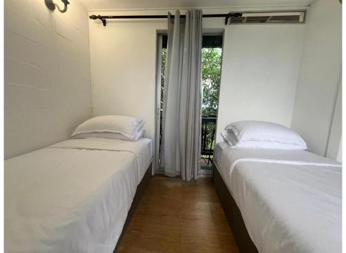 two beds in a room with a window at OYO 91261 Thebukit, Langkawi in Kuah