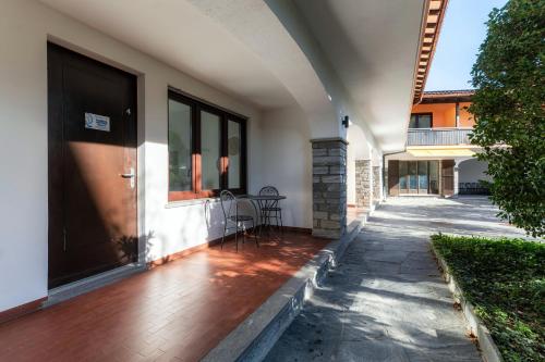 - une terrasse couverte à l'avant d'une maison avec une porte dans l'établissement Florida Ascona Rooms by Quokka 360 - Close to Lake and City, à Ascona