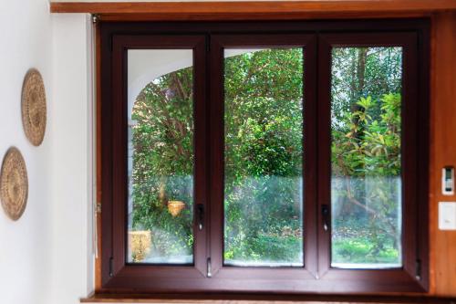 a window in a room looking out at a garden at Florida Ascona Rooms by Quokka 360 - Close to Lake and City in Ascona