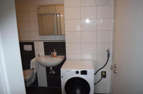 a small bathroom with a sink and a washing machine at LK Apartment 01 in Gronau
