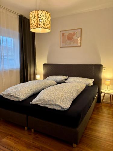 a bedroom with a bed with two pillows on it at LA-Hüttenfeld Erdgeschoss Apartment in Lampertheim