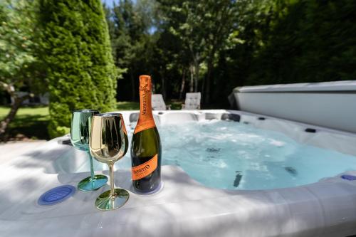 a bottle of wine and two glasses next to a hot tub at Serenity Villa Prague with Garden and Jacuzzi in Prague