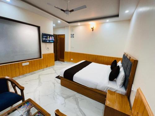 Un dormitorio con una cama y un televisor de pantalla plana. en Aradhya Stays Chail, en Jāmb