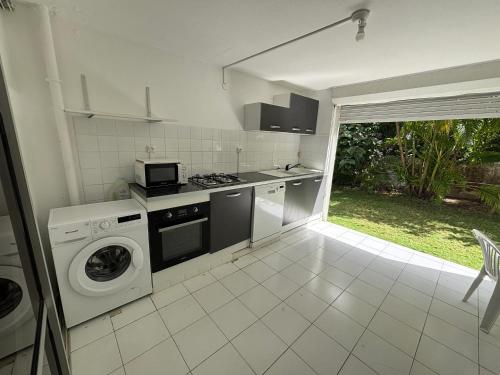a kitchen with a washer and dryer in it at Studio moderne à Saint-François, 38 m² avec piscine in Saint-François