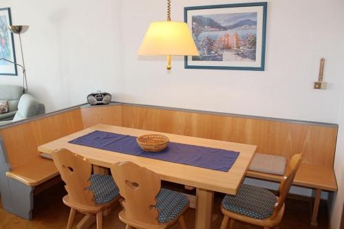 Ferienhaus Nr 46, Kategorie Komfort L, Feriendorf Hochbergle, Allgäu في Karlsebene: طاولة طعام وكراسي مع طاولة ومصباح