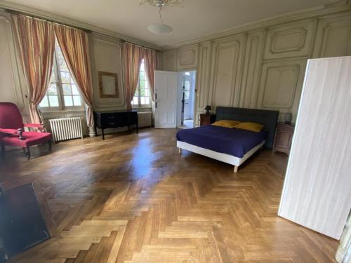 a bedroom with a bed and a wooden floor at Manoir de Bolbec in Bolbec
