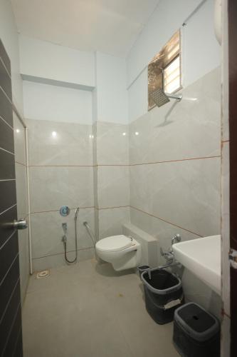a bathroom with a shower and a toilet and a sink at Teja Hotel in Lūnāvāda