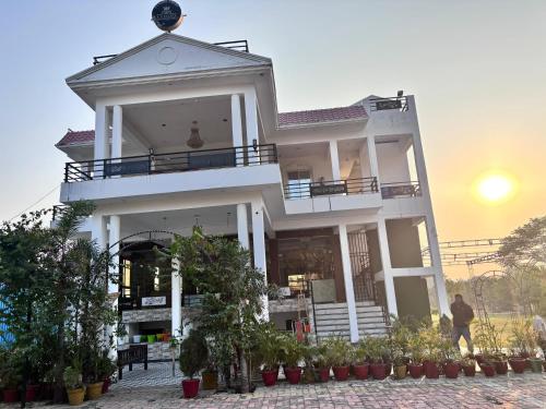 a large white building with a balcony on top at R D Palace and Resort in Bhauli