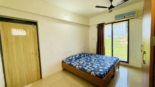 a bedroom with a bed and a large window at Bhakti Bliss Homestay - New Luxury 2bhk apartment in Tirupati with Kitchen and car parking in Tirupati