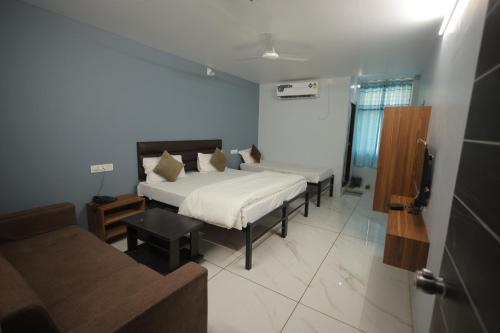 a bedroom with a bed and a couch in a room at Teja Hotel in Lūnāvāda