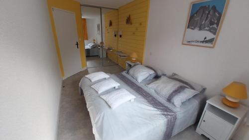 un dormitorio con una cama con sábanas y almohadas blancas en Arriu Mage 105, en Bielle