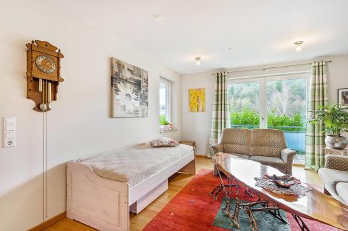 a bedroom with a bed and a table and a clock at Ferienwohnung am Schmenkenberg in Marsberg