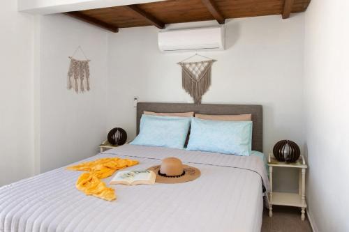 a bed with a hat and a book on it at Triopetra Green Dream in Triopetra
