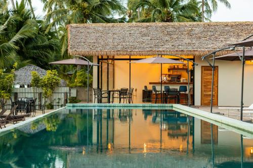 a resort with a swimming pool with chairs and umbrellas at Samaraya Wellness Resort - Adults Only in Lipa Noi