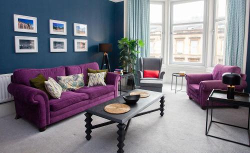 a living room with purple couches and a table at Newly Renovated Flat in Trendy Finnieston in Glasgow