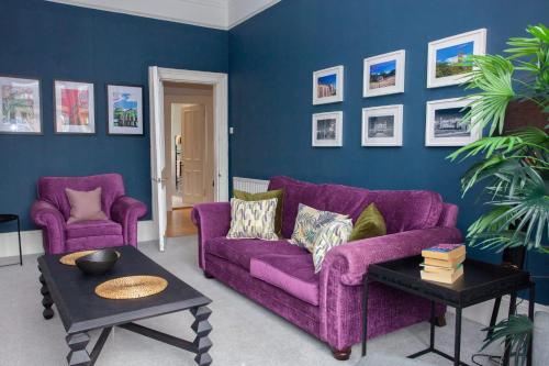 a purple couch and two chairs in a living room at Newly Renovated Flat in Trendy Finnieston in Glasgow