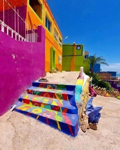 Un grupo de escaleras frente a un edificio colorido. en Aghrour Village & Timlaline Dunes Adventure, en Taghazout