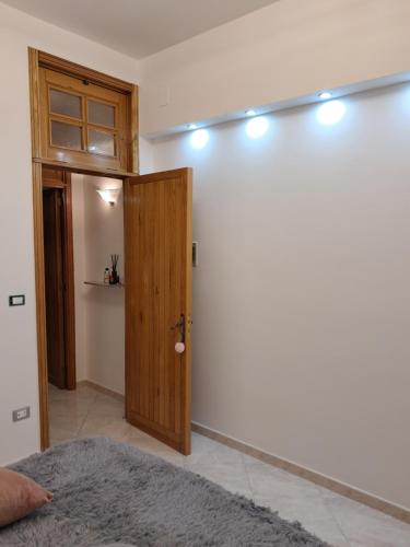 Habitación con puerta de madera y pared blanca en B&b Mythos, en Tuglie