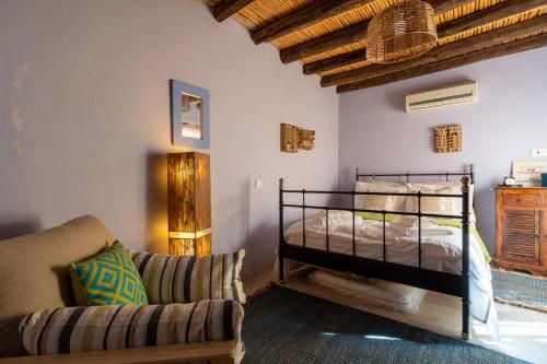 a bedroom with a bed and a couch in a room at Villa Monti Cozy Yard & BBQ Perfect for Families & Friends in Kato Lefkara
