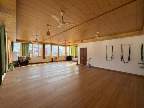 a large room with a wooden ceiling and wood floors at Happy Homes by Yoga & Smiles, Upper Tapovan in Rishīkesh