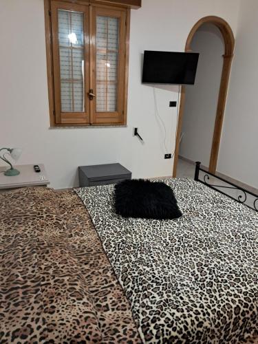 Dormitorio con cama de leopardo con espejo en B&b Mythos, en Tuglie