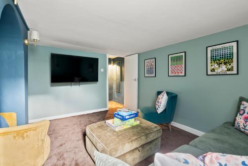a living room with a couch and a tv at Victorian 5-Bed Home, Loft, Walk to City & Cricket in Worcester
