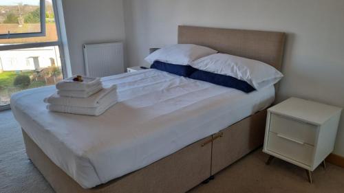 a bedroom with a large bed with white sheets and pillows at Modern 2 bed flat with balcony in Southend-on-Sea