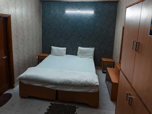a bedroom with a large bed with white sheets at Hotel O by OYO Radha Raman Guest House in Rait