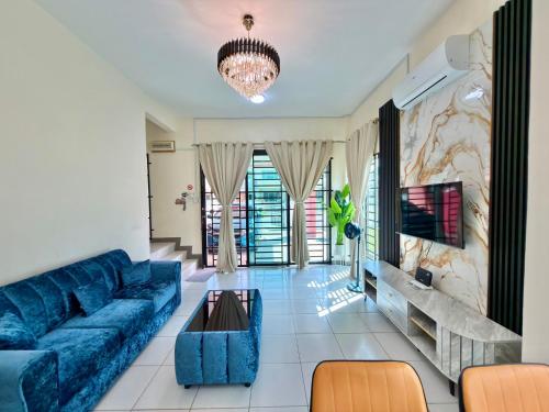 a living room with a blue couch and a chandelier at EQAMEL Homestay in Sandakan