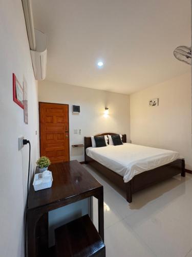 a bedroom with a bed and a table in it at บ้านในฝัน เชียงคาน in Chiang Khan