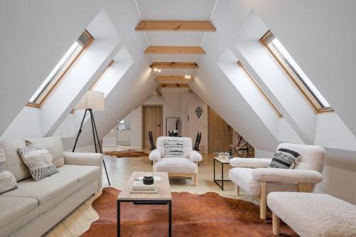 a living room with white furniture and skylights at Apartamenty SKI Apartments, Odkryj-Bialke in Białka Tatrzańska