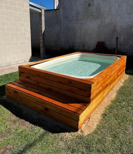 a hot tub in a wooden box in the grass at Quintas Barceló in Baradero