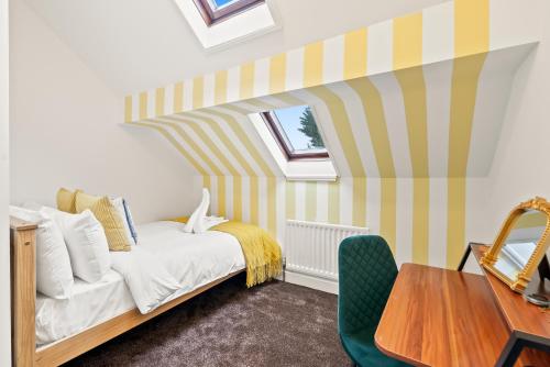 a bedroom with a bed and a table at Victorian 5-Bed Home, Loft, Walk to City & Cricket in Worcester