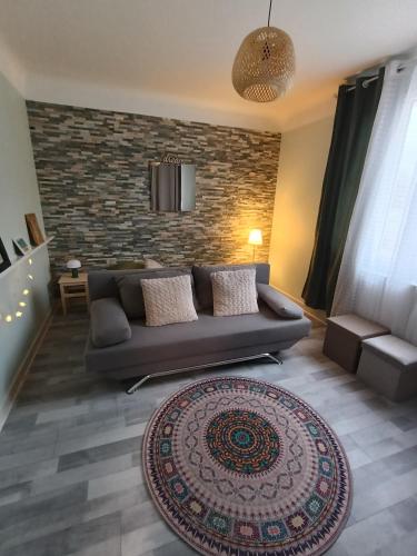 a living room with a couch and a brick wall at La Gilbertine in Louze