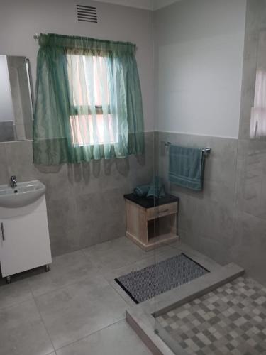 a bathroom with a sink and a toilet and a shower at Flamingo Holiday Flats in St Lucia