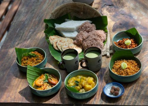 un grupo de tazones de comida sobre una mesa de madera en Wild Monkey Jungle Villa - 4 Bedroom Villa, en Unawatuna