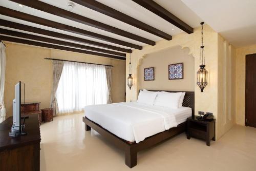 um quarto com uma cama e uma TV de tela plana em Dewan Bangkok em Banguecoque