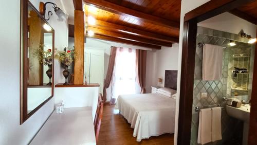 a bedroom with a bed and a bathroom with a mirror at Li Muntigeddi in San Teodoro