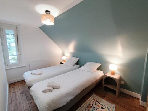 2 Betten in einem kleinen Zimmer mit 2 Lampen in der Unterkunft L'ancienne Poste in Fort-Mahon-Plage