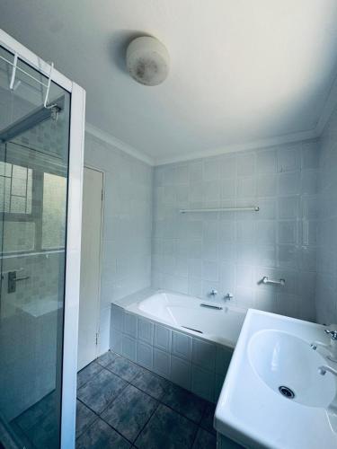 a bathroom with a tub and a sink and a shower at Sea and Vlei on Disa in Bettyʼs Bay