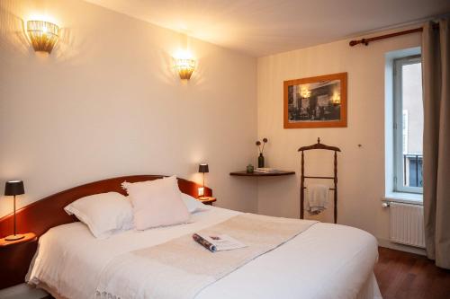 Un dormitorio con una cama con un libro encima. en Un grain d'folie, en Villié-Morgon