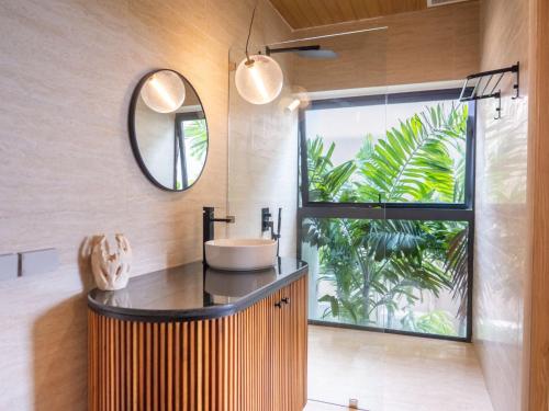 a bathroom with a sink and a mirror at Homey 2Br Villa Apricot Close to Beach Sea View in Plai Laem