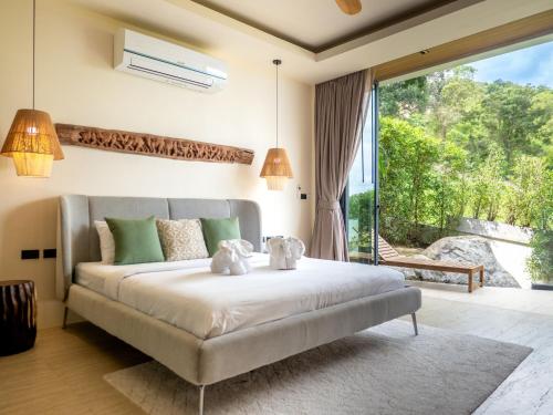 a bedroom with a bed and a large window at Homey 2Br Villa Apricot Close to Beach Sea View in Plai Laem