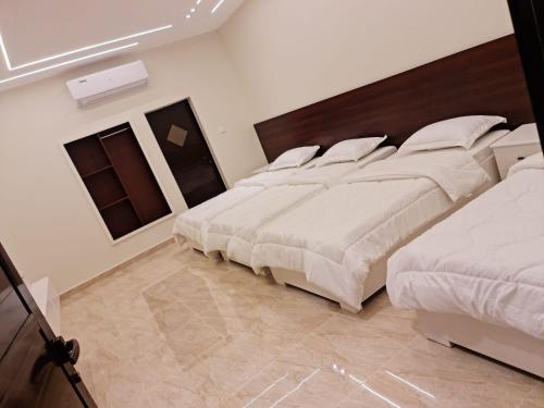 a bedroom with two beds with white sheets at Daftah Valley Farmhouse in Daftah
