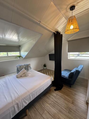 a bedroom with a bed and a blue chair at Villa Hana'iki in Paui
