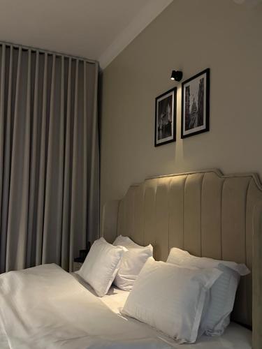 ein Schlafzimmer mit einem Bett mit weißen Laken und Kissen in der Unterkunft استديو هادئ بدخول ذكي in Ar Rass